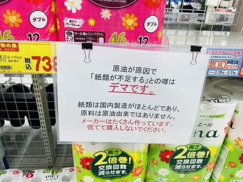 ドラッグストアの棚に掲げられた「紙類が不足するとの噂はデマです」という貼り紙。