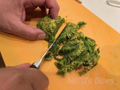 茹でて絞ったふきを包丁で刻んでいる様子。